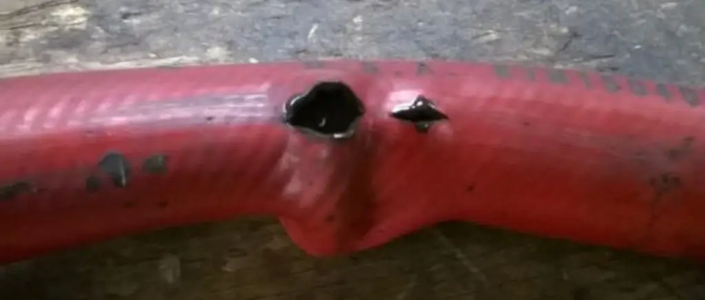 red broken hydraulic hose
